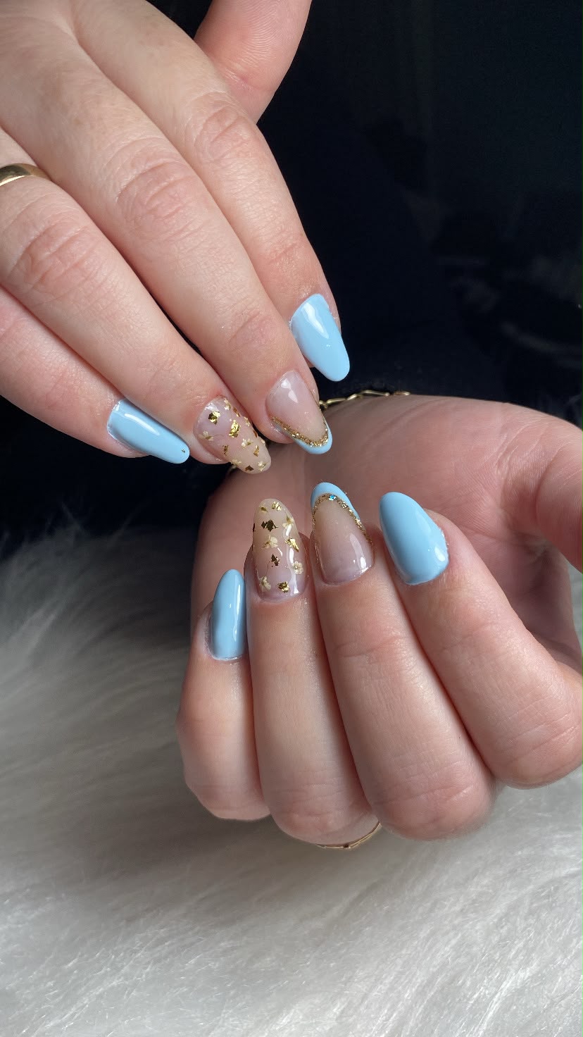 Unhas em amêndoa azul bebê com nail art de flores e folhas douradas feitas pela Bruna